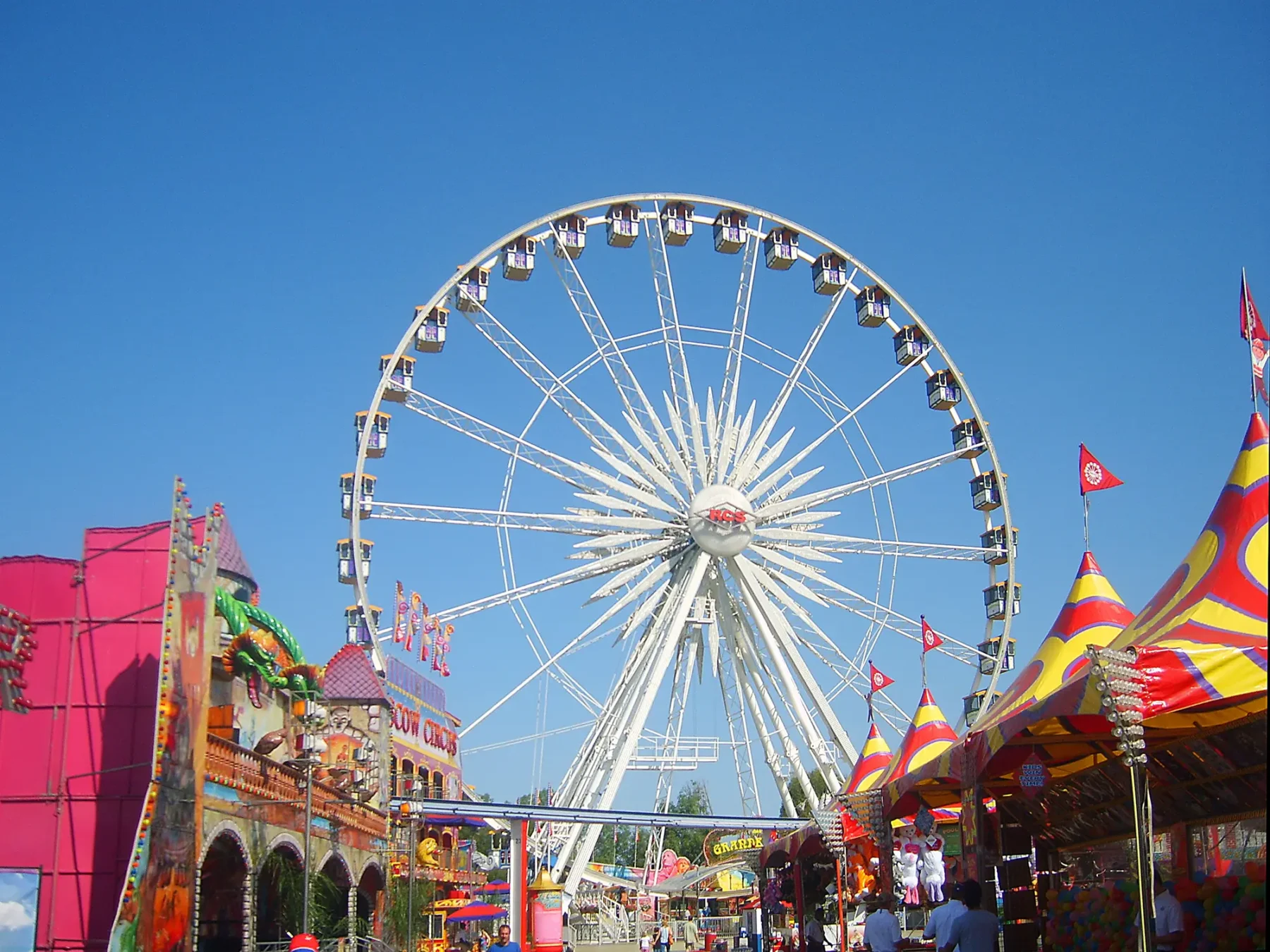 Carnival with tents, booths, and ferris wheel.